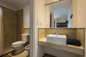 玛德琳港托斯卡旅舍的一间带水槽、卫生间和镜子的浴室