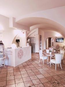 加尔达湖滨里瓦米亚酒店的一间在房间内配有白色椅子和桌子的餐厅