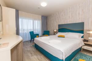 马马亚利维埃拉酒店的一间卧室配有一张大床和蓝色的椅子