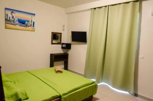 法里拉基Maestro Apartments Faliraki的一间卧室配有绿色的床和绿色窗帘