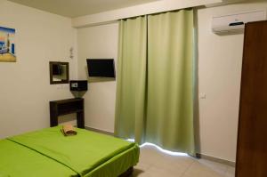 法里拉基Maestro Apartments Faliraki的一间卧室配有绿帘和一张床