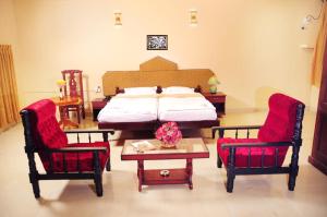 KondottiHotel Nuhman的一间卧室配有一张床、两把椅子和一张桌子