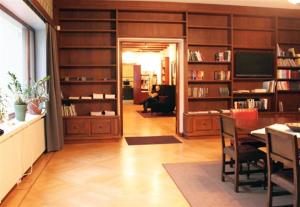 曼塔洪克霍威艺术酒店的客厅设有餐桌和书架