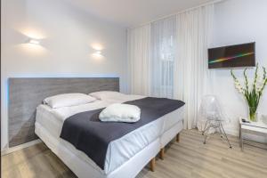 米兹多洛杰Villa Rosa - 200m od morza的一间卧室配有一张大床和一台平面电视