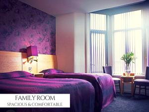 布莱克浦皇家亚历山德拉酒店的一间卧室配有一张带紫色毯子的床
