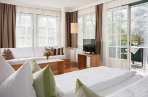 施特罗布尔Hotel Brandauers Villen Superior的酒店客房设有两张床和电视。
