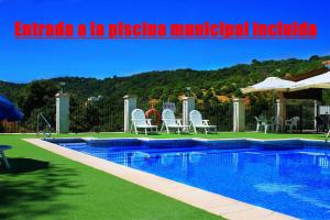胡斯卡尔夫恩特卡莱拉乡村度假屋的庭院内一个带椅子和遮阳伞的游泳池
