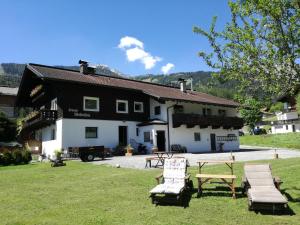 莱尔莫斯Ferienwohnung Wetterstein的黑白的建筑,长有长凳,在草地上