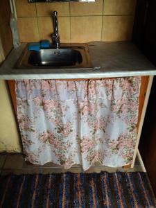 KassariLittle Garden House的厨房柜台配有水槽和窗帘