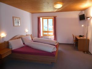 贝尔金普雷达库尔姆酒店的一间卧室配有一张床、一个窗口和一张书桌