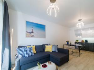 尤斯托尼莫斯基Lucky40 - Apartament z widokiem na morze, SPA gratis, Dwie Sosny的客厅设有蓝色的沙发和灯塔。