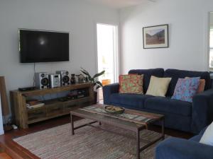 科罗曼德镇Coromandel Eco Sanctuary的客厅配有蓝色的沙发和茶几