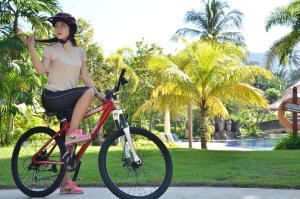 圣吉吉Merumatta Senggigi Lombok的一位妇女坐在公园里的自行车上