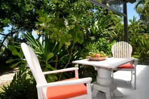 米申海滩思雅拉海滩小屋酒店的两张椅子和一张桌子,上面放着一碗水果