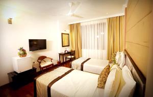 康提伯爵康提城市酒店的酒店客房设有两张床和电视。