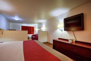 图珀洛Super 7 Inn的配有一张床和一台平面电视的酒店客房