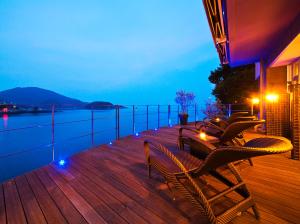 福山米格瓦特欧驰卡慈酒店的一个带椅子和桌子的甲板,享有水景
