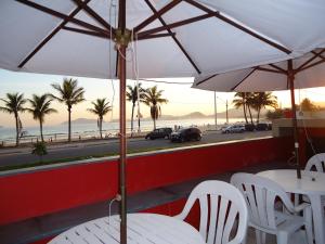瓜鲁雅米拉马雷普拉亚酒店的一张桌子和椅子,配有遮阳伞和海滩
