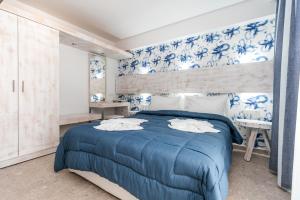 佩弗卡里The Elegant Apartments的一间卧室配有蓝色的床和蓝色及白色的壁纸