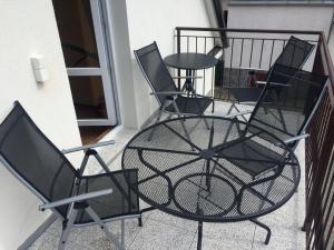布兰斯科Penzion U Golema Blansko的阳台上的一组椅子和一张桌子