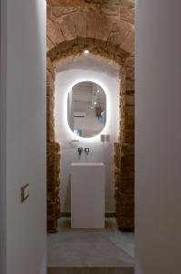 佛罗伦萨领主广场迪勒旅馆的浴室配有白色水槽和石墙