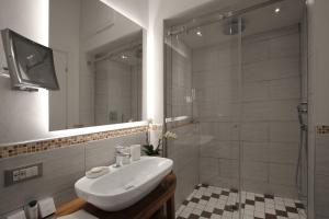 佛罗伦萨领主广场迪勒旅馆的浴室配有白色水槽和淋浴。