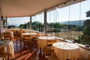 圣特雷莎加卢拉米拉奇酒店的餐厅设有桌椅和大窗户。