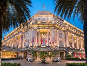 新加坡The Fullerton Hotel Singapore的前面有三辆车的建筑