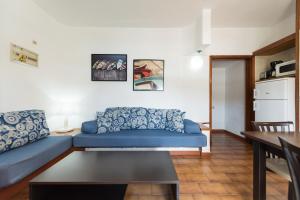 英格兰海滩佩德罗公寓的客厅配有蓝色的沙发和桌子