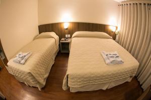 圣玛丽亚Hotel Dom Rafael Premium的两张位于酒店客房的床,配有毛巾