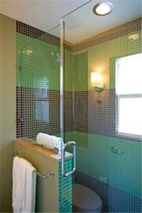 基韦斯特杜鲁门酒店的浴室设有绿色瓷砖淋浴间和玻璃门