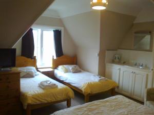 伯恩茅斯金斯利酒店的一间卧室设有两张床和窗户。