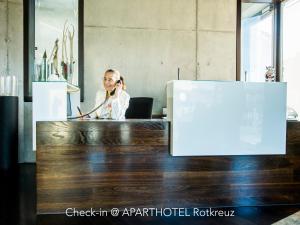 里施Hotel Bauernhof - Self Check-In Hotel的办公室里的一个女人在说手机