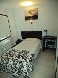 Aixovall普拉堡酒店的卧室配有黑白床和椅子