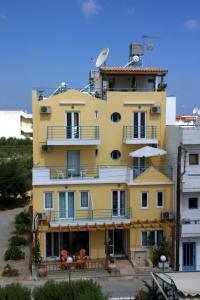 赫索尼索斯Olympic Star的黄色的建筑,旁边设有阳台
