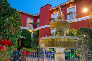 马拉加Hotel Romerito的红色房子前面的喷泉