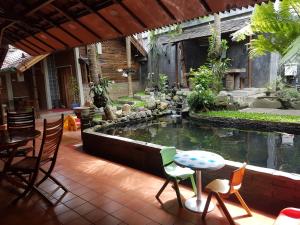 玛琅佩耶旅馆的庭院设有带椅子和桌子的池塘。