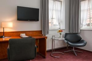 哈默尔恩加尼克里斯蒂伦贺夫历史酒店的酒店客房配有书桌、椅子和电视。