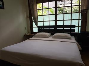玛琅佩耶旅馆的窗户客房内的一张大白色床