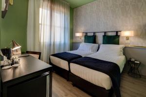 佛罗伦萨佛罗伦萨CHC贝斯特韦斯特优质酒店的酒店客房设有一张大床和一张书桌。
