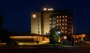 圣玛丽亚大德费拉诺瓦克鲁斯酒店的夜间有灯光标志的酒店大楼