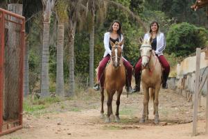 塞拉内格拉大峡谷庄园酒店的两名妇女骑在土路上骑马