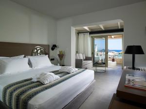 依拉佩特拉Kakkos Beach Hotel - Adults Only的一间带大床的卧室和一间客厅