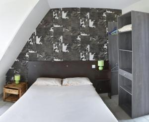 Plouarzel多梅因科租阿特旅馆的一间卧室设有一张大床和一面墙