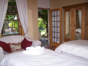 Ladybrand佳屋住宿加早餐酒店的一间卧室设有两张白色的床和窗户