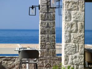 依拉佩特拉Kakkos Beach Hotel - Adults Only的一张桌子和椅子,坐在石柱旁