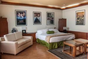 阿特利斯科埃斯梅拉达酒店的一间卧室配有一张床、一张沙发和一把椅子