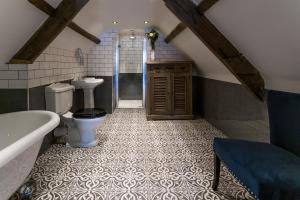 阿尼克The Dirty Bottles Inn的浴室配有卫生间、浴缸和水槽。