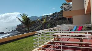 丰沙尔Vista Formosa Funchal的阳台,带椅子的建筑和大海