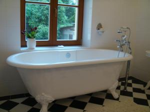 柏林酷尔孜别墅酒店的带窗户的浴室内的白色浴缸